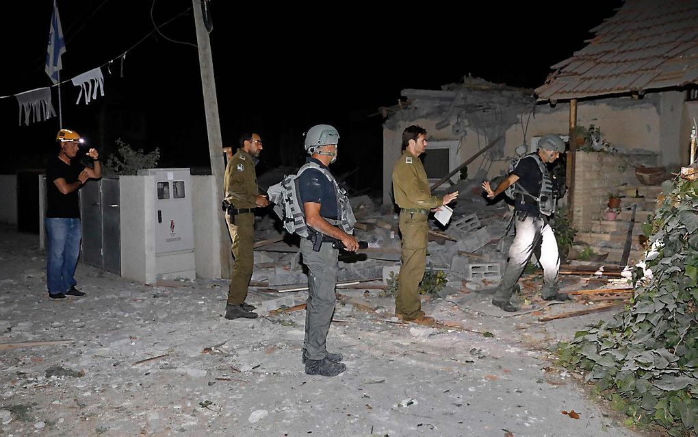 Israëliscbe militairen nemen de schade aan een huis in Yehud bij Tel Aviv in ogenschouw. beeld AFP, GIL COHEN-MAGEN