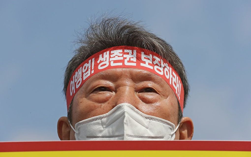 Een Zuid-Koreaanse man uit de reisbranche demonstreert om de overheid op te roepen om de reisbranche te steunen. De tekst op de band luidt: „Garandeer de reisbranche haar bestaansrecht”. beeld EPA, Yonhap