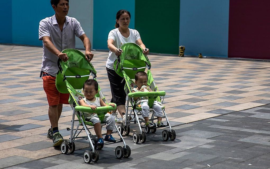 Ouders met kinderen in Peking. beeld EPA, ROMAN PILIPEY