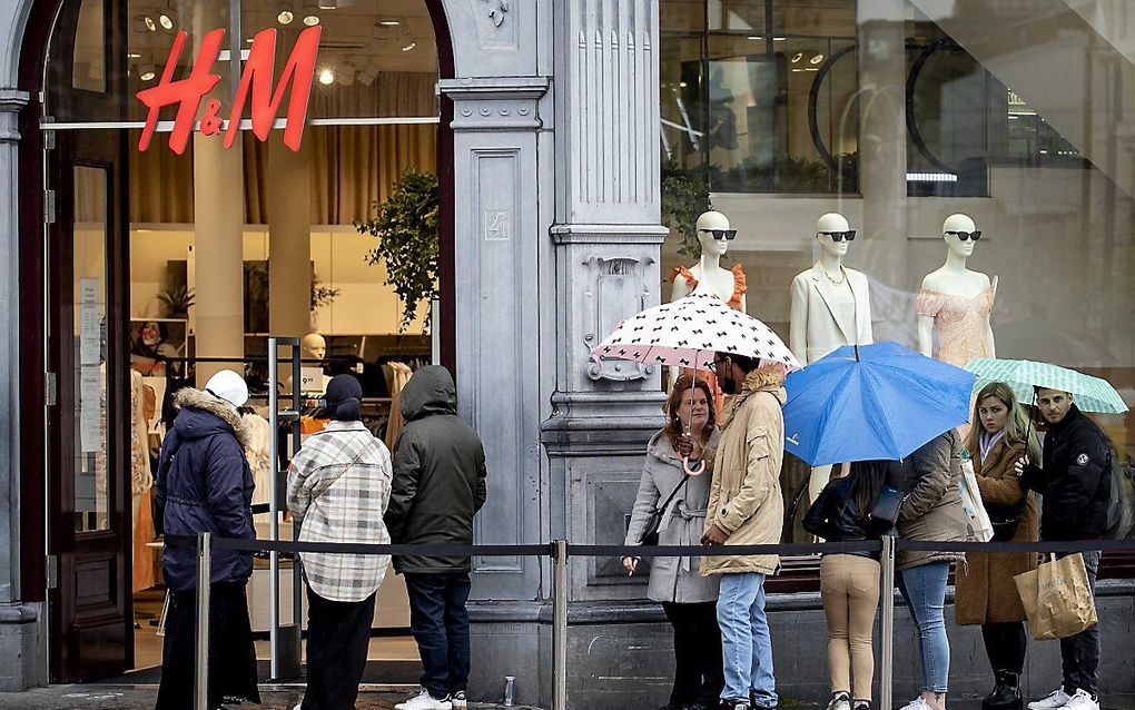 Winkelend publiek in de rij voor kledingwinkel H&M in Amsterdam, begin mei. beeld ANP, Koen van Weel