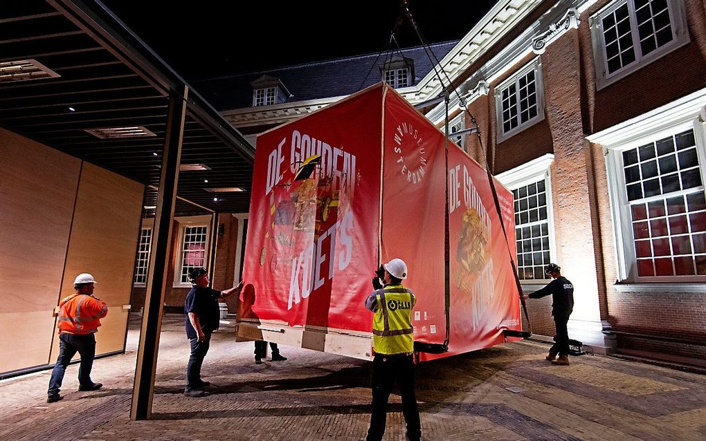 Met een enorme hijskraan is de Gouden Koets naar de binnenplaats van het Amsterdam Museum getakeld. De gerestaureerde Gouden Koets, die ruim 2.800 kilo weegt, is hier als middelpunt van een gelijknamige tentoonstelling acht maanden lang van dichtbij te zien voor publiek. beeld ANP, Olaf Kraak