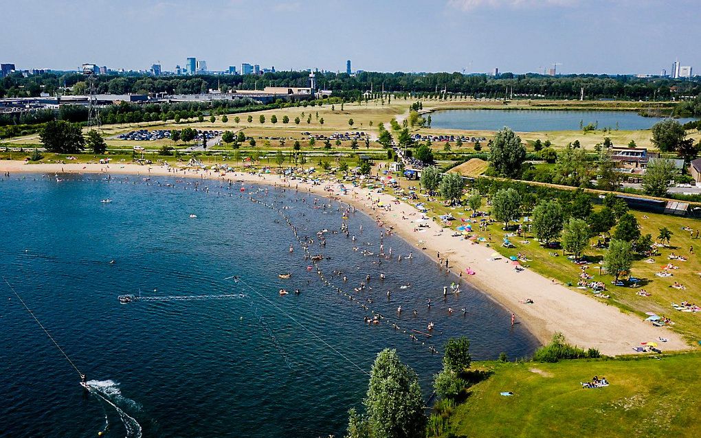 Dronefoto van strandgangers bij Plas Laagraven. Het tropisch warme weer trekt badgasten naar de stranden toe. beeld ANP, SEM VAN DER WAL