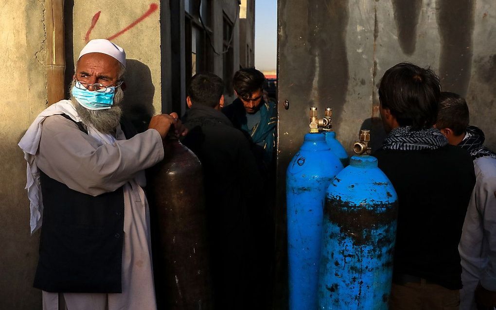 Afghanen wachten bij een zuurstoffabriek in Kabul op het moment dat ze hun lege flessen kunnen vullen. Vanwege het oplopende aantal coronagevallen dreigt een zuurstoftekort in Afghaanse ziekenhuizen. beeld EPA, HEDAYATULLAH AMID