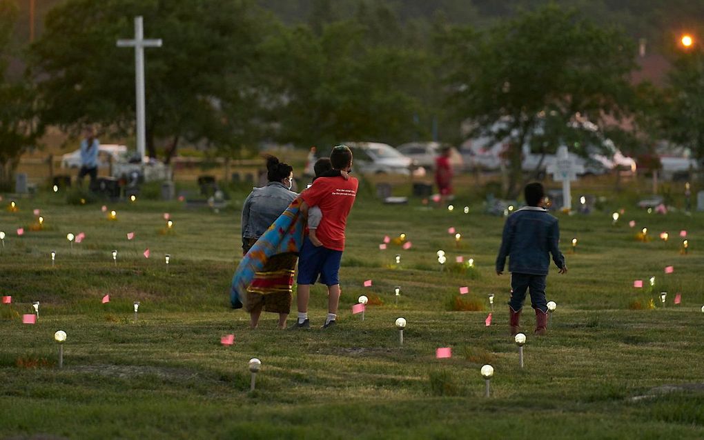 Vlaggetjes en lichtjes markeren doden die anoniem zijn begraven bij scholen en kerken. beeld AFP, Geoff Robins