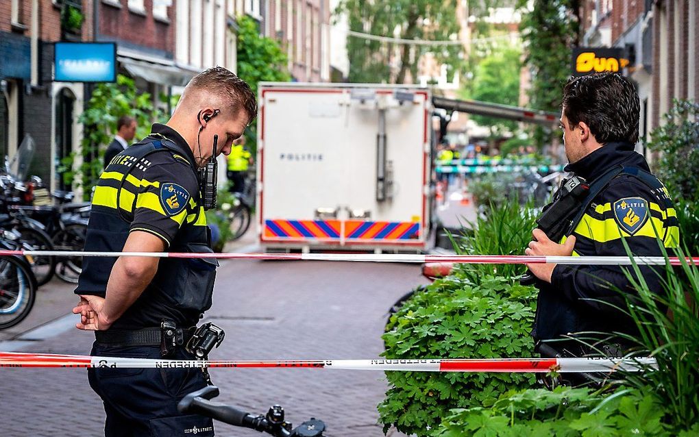 Politieagenten dinsdag bij de locatie waar misdaadjournalist Peter R. de Vries werd neergeschoten. beeld ANP, Evert Elzinga