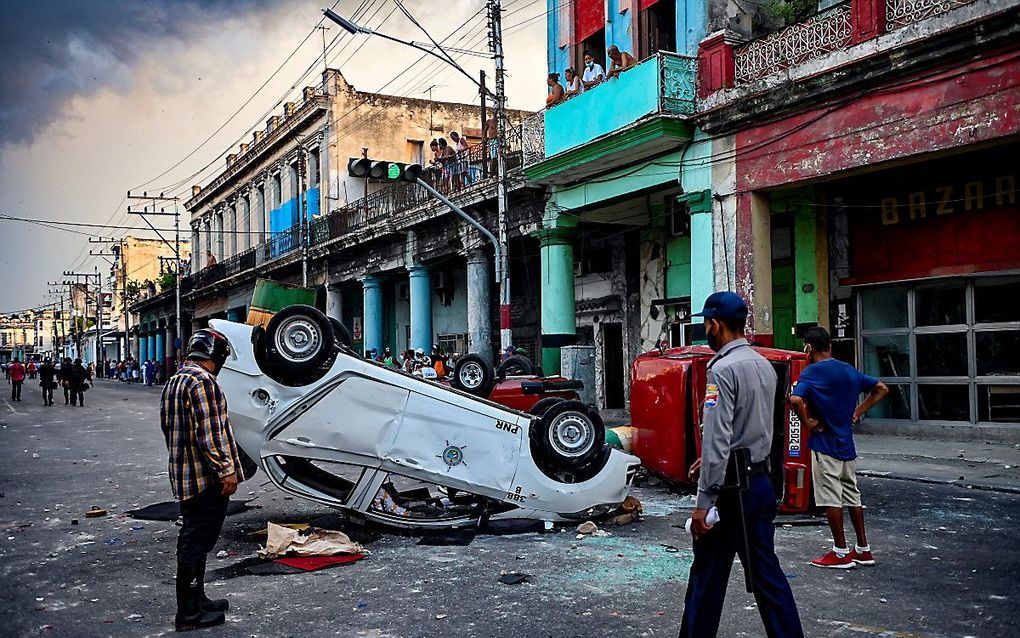 Een politieauto is omgegooid in Havana. beeld AFP, YAMIL LAGE