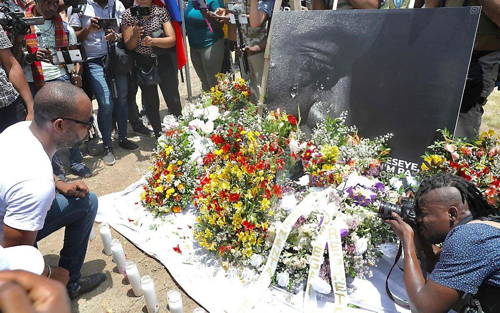 Haïttianen leggen bloemen voor het presidentieel paleis in de hoofstad Port-au-Prince nadat president Jonevel Moïse is vermoord. beeld AFP, Valerie  Baeriswyl