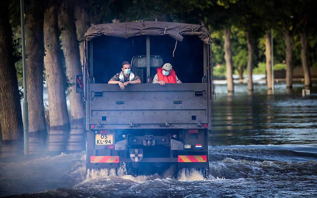 Bewoners kunnen met hulp van een pendeldienst, uitgevoerd door defensie, door het hoge water van de Maas tussen Bergen en Nieuw Berge worden vervoerd. beeld ANP, Vincent Jannink