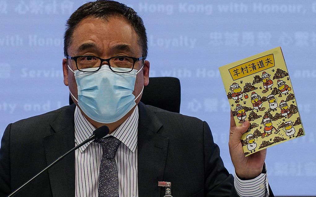 Politiefunctionaris Steve Li toont drie kinderboeken op een persconferentie. beeld AFP, Daniel Suen