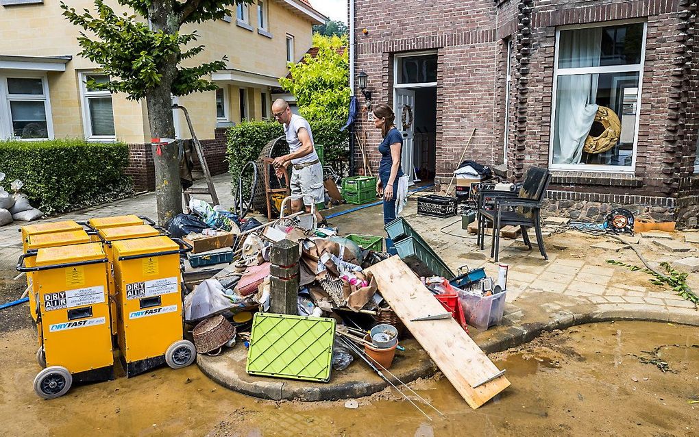 Inwoners ruimen puin na de wateroverlast in Valkenburg aan de Geul. beeld ANP, Marcel van Hoorn