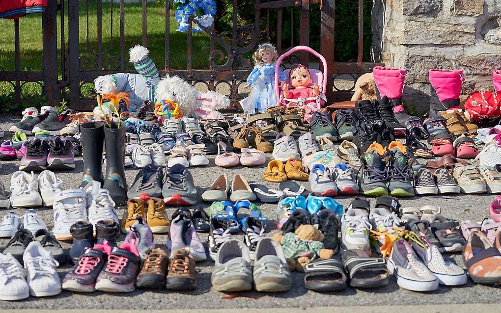 Schoenen, poppen en knuffels bij een katholieke kerk in Canada als protest tegen de ontdekking van anonieme graven. beeld EPA, Andre Pichette