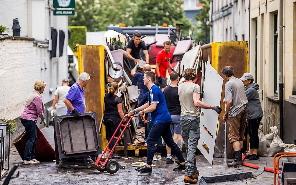 Inwoners ruimen puin na de wateroverlast in Valkenburg aan de Geul. beeld ANP, MARCEL VAN HOORN