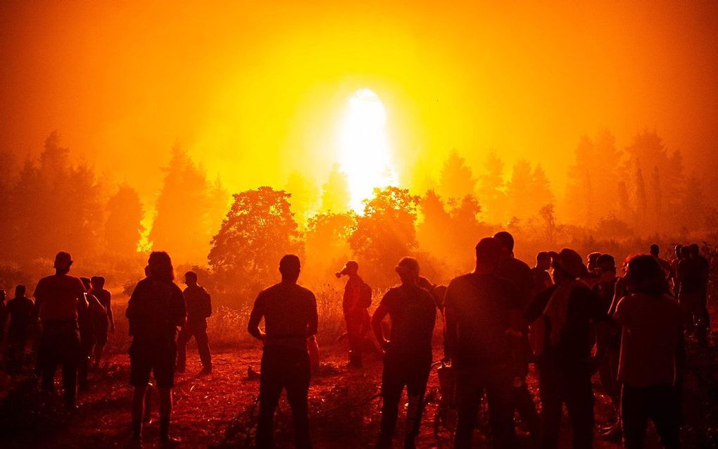 Vrijwilliger in de buurt van Kamatriades wachten totdat ze de brandweer kunnen helpen. Beeld AFP, Angelos Tzortzinis