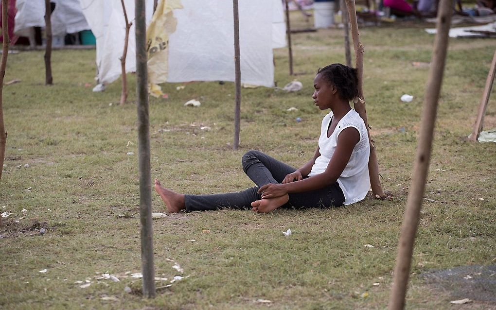 Een vrouw schuilt voor de regen in een tijdelijk onderkomen. Het door een aardbeving getroffen Haiti maakt zich op voor een tropische storm. beeld EPA, Orlando Barria