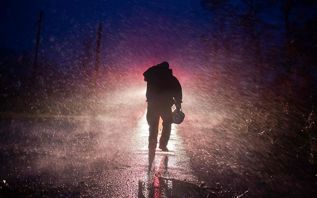 Een brandweerman trotseert de storm om omgevallen bomen weg te halen in Bourg, Louisiana. beeld AFP, Mark Felix