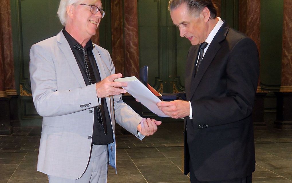 Wethouder Bert van Alphen (l.) reikt Ben van Oosten de penning met oorkonde uit. beeld Pieter Baak