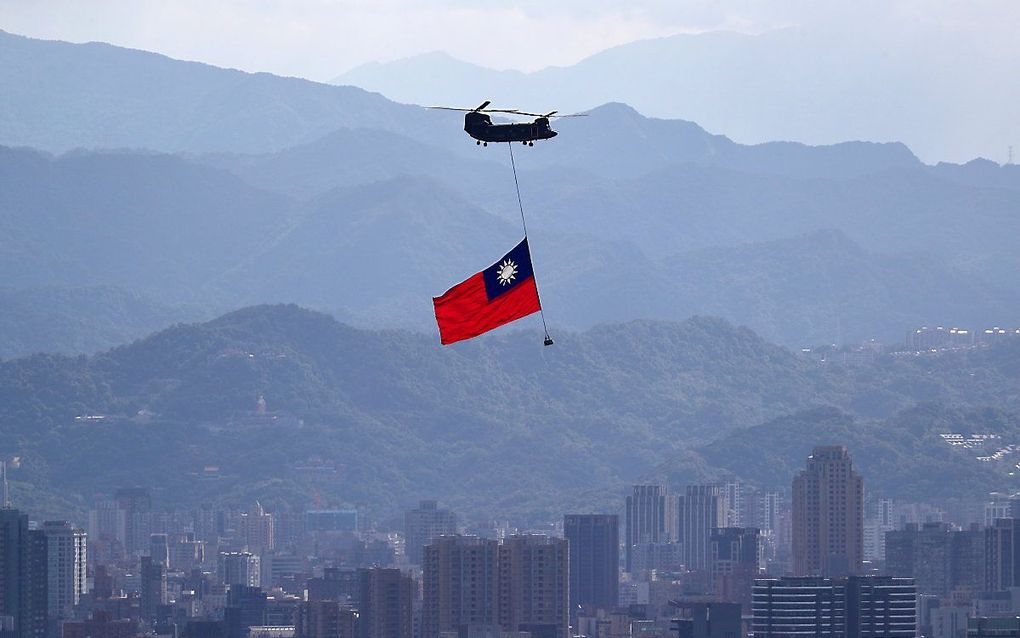 Een Chinook helicopter draagt de Taiwanese vlag tijdens een oefening voor de nationale feestdag, op 10 oktober. beeld EPA, Ritchie B. Tongo