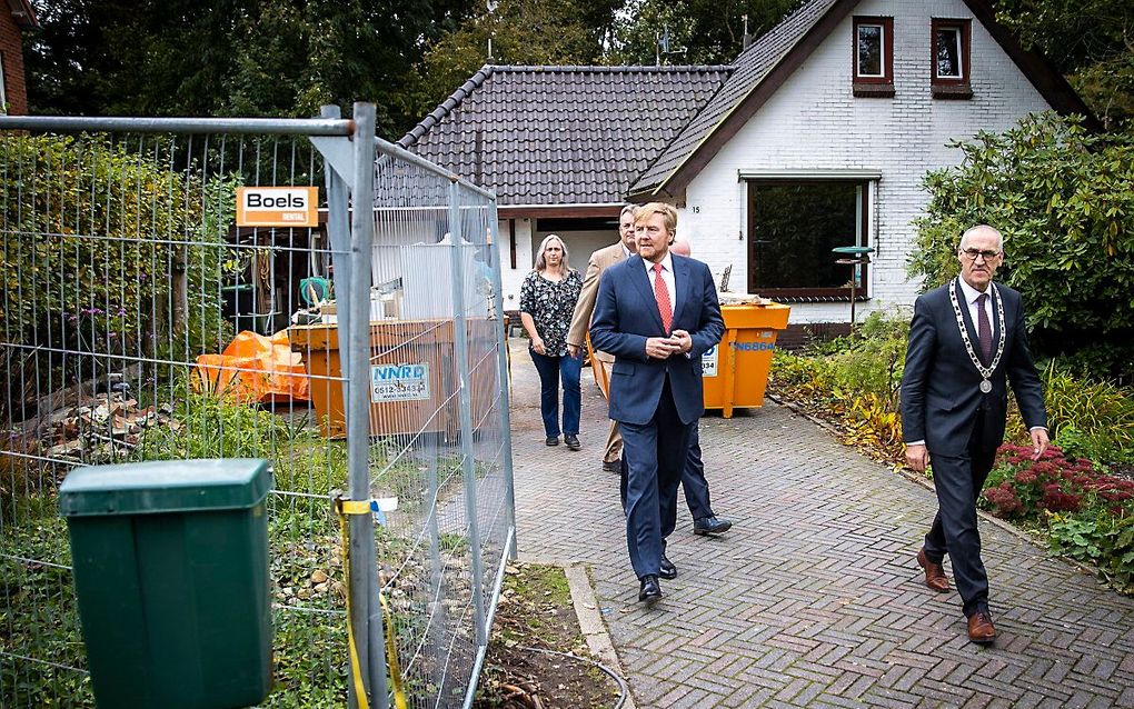 Koning Willem-Alexander neemt in aanwezigheid van burgemeester Adriaan Hoogendoorn (Midden-Groningen) een kijkje bij een huis met aardbevingsschade dat in aanmerking komt voor versterking. beeld ANP,  VINCENT JANNINK