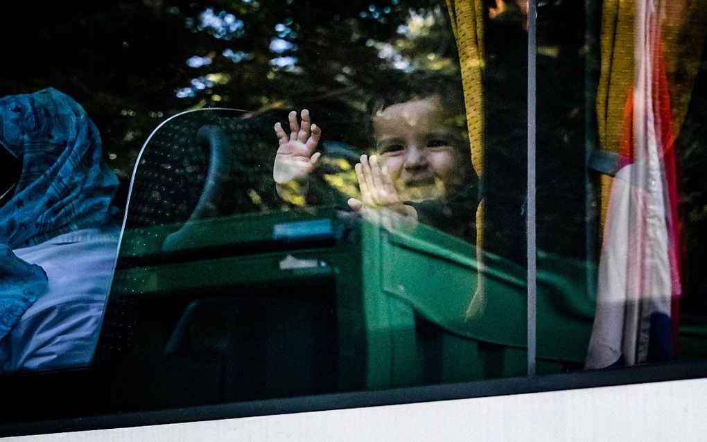 Een bus met Afghaanse vluchtelingen arriveert bij tijdelijk asielzoekerscentrum Heumensoord. beeld ANP, Rob Engelaar