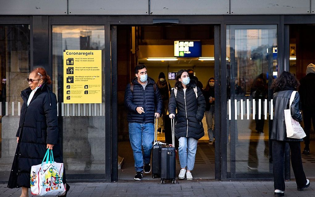 Mensen met mondkapjes op bij het centraal station van Amsterdam. Het wordt weer verplicht om een mondkapje te dragen in de supermarkt en andere winkels en op de stations. beeld ANP, RAMON VAN FLYMEN