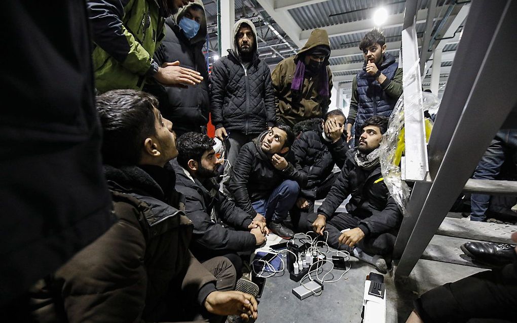 Asielzoekers, vluchtelingen en migranten laden hun telefoons op in checkpoint 'Bruzgi', bij de Pools-Wit-Russische grens. beeld EPA / STRINGER