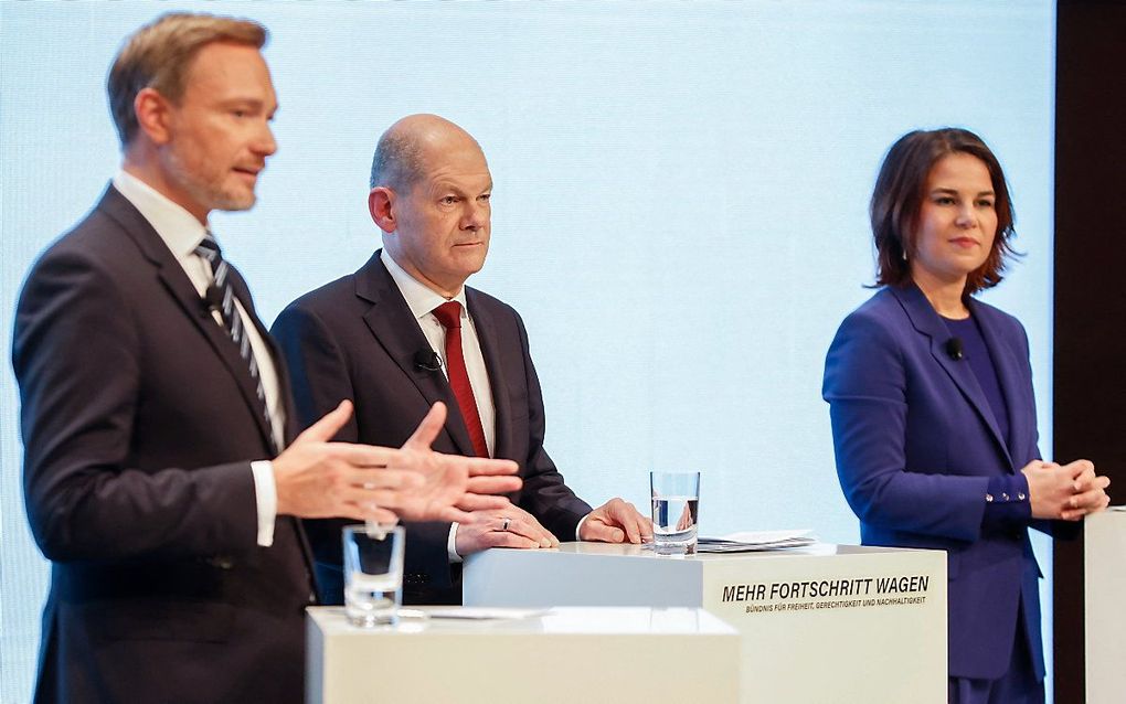 Christian Lindner (FDP), Olaf Scholz (SPD) en Annalena Baerbock (Groenen) op de persconferentie. beeld AFP, Odd Andersen