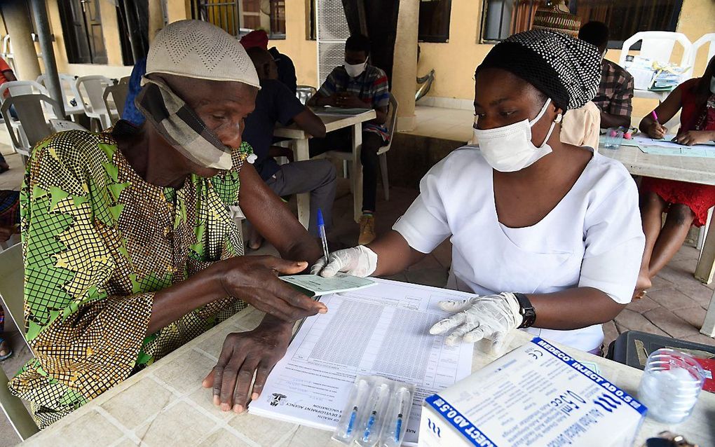 Een man krijgt een vaccinatiebewijs in de Nigeriaanse stad Lagos, na geprikt te zijn met het AstraZeneca-vaccin. beeld AFP, Pius Utomi Ekpei