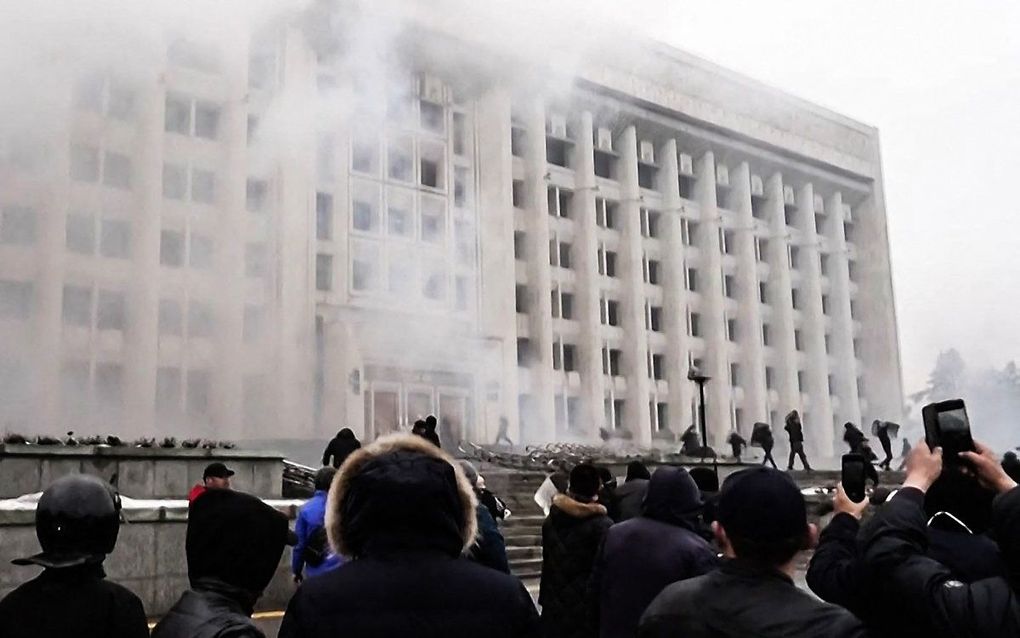 Een op 6 januari 2022 opgenomen beeldfragment uit een video van 5 januari 2022 toont demonstranten die het stadhuis van de grootste stad van Kazachstan, Almaty, bestormen. beeld AFPTV / AFP, Alexander PLATONOV