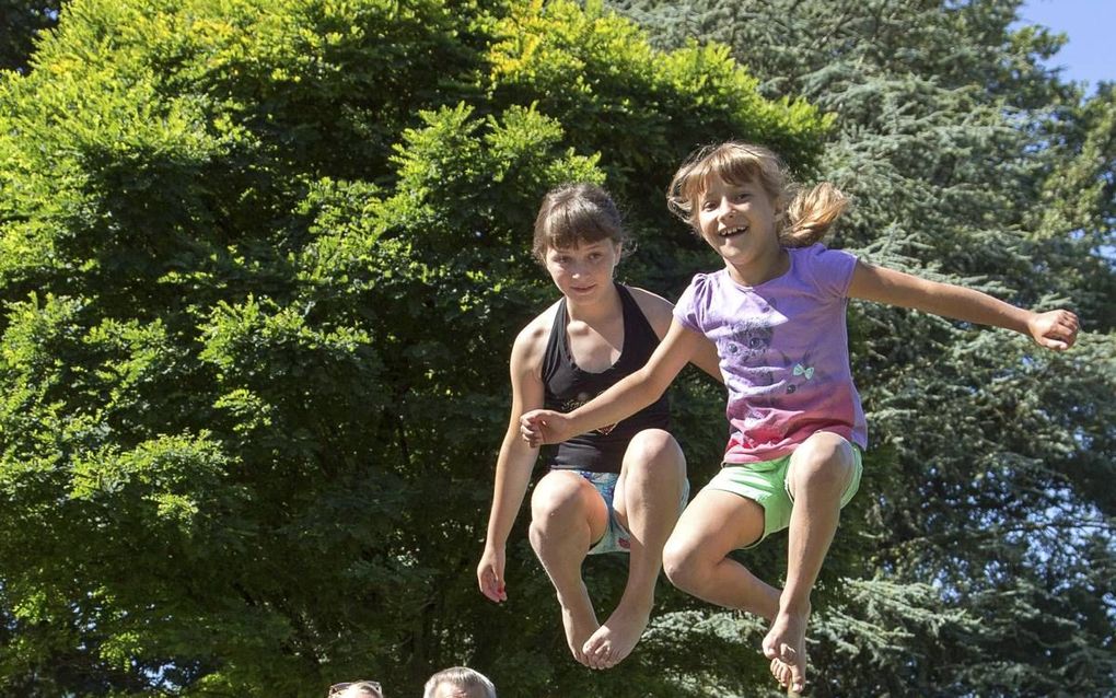 De familie Schonewille vangt elke zomer Wit-Russische kinderen op. „Zij ervaren hier vooral geborgenheid en veiligheid, maar ook structuur.” V.l.n.r.: Paula, Anita, Arend, Ruben, in de lucht hangen Katja en Luba.  beeld Fotopersburo Jacob Melissen