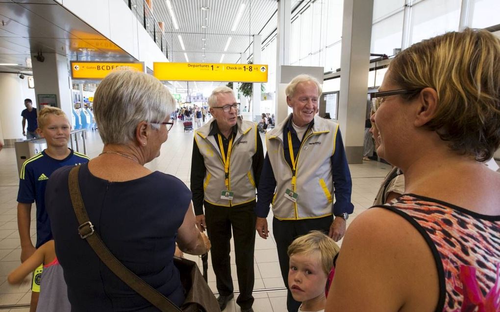 SCHIPHOL. Twee oud-medewerkers van Schiphol wijzen reizigers de weg op de luchthaven. beeld RD, Anton Dommerholt