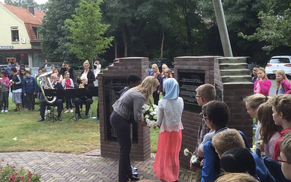 EDE. Twee schoolkinderen reikten wethouder Eleveld gisteren een bloemenkrans aan. Ede-Zuid herdacht het bombardement van 1944. beeld RD