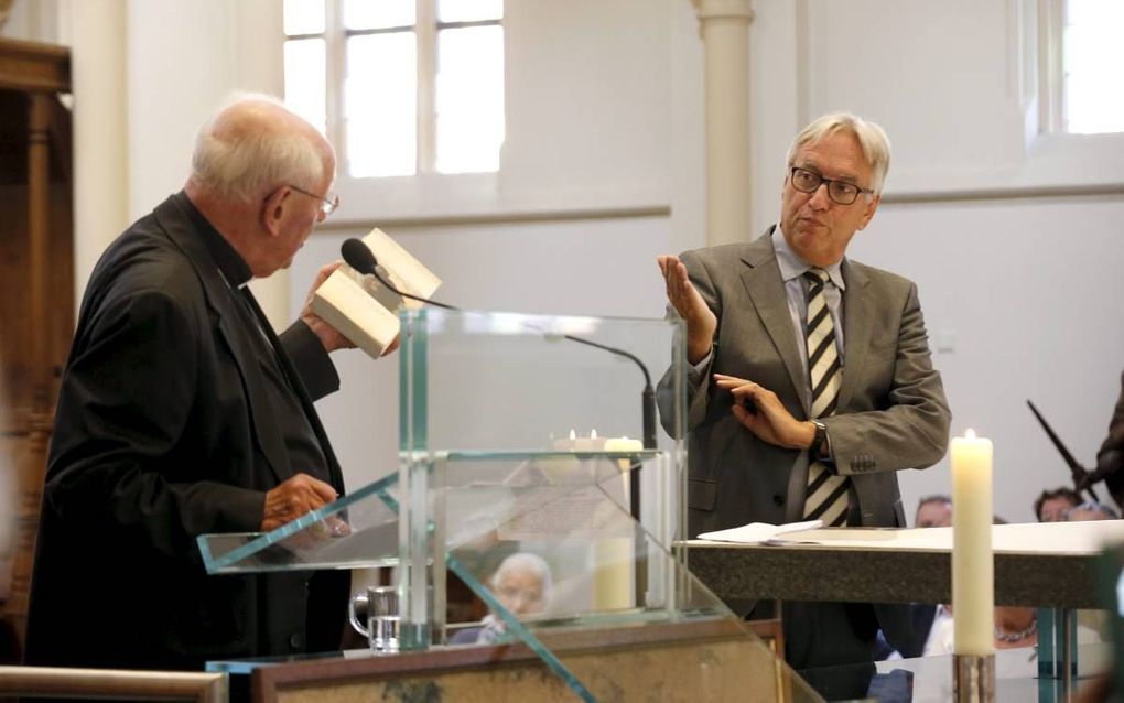 In de Abdij van Berne in Heeswijk werd vrijdag een symposium gehouden over het boek ”Het geheim van de paus” van Andries Knevel (r.). Kardinaal A. J. Simonis (l.) nam een exemplaar van het boek in ontvangst. beeld Bert Jansen