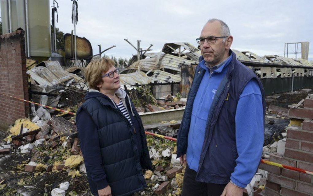 Kees de Jong en zijn vrouw voor de puinhopen van zijn gisteren afgebrande kippenboerderij in Waddinxveen. „Hoe moeten we verder? Mijn vrouw en ik zoeken de weg die we moeten gaan. Het antwoord hebben we nog niet.” beeld Bram Gebuys