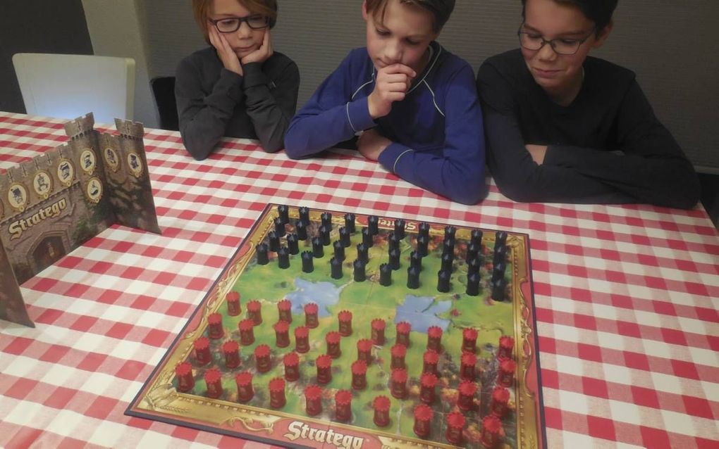 De broertjes (v.l.n.r.) Thomas (8), Daniël (12) en Bram (14) Geelhoed zijn stapelgek op het denkspel Stratego. Zaterdag doen ze mee aan het Nederlands Kampioenschap in hun woonplaats Houten. beeld Steven van den Berg