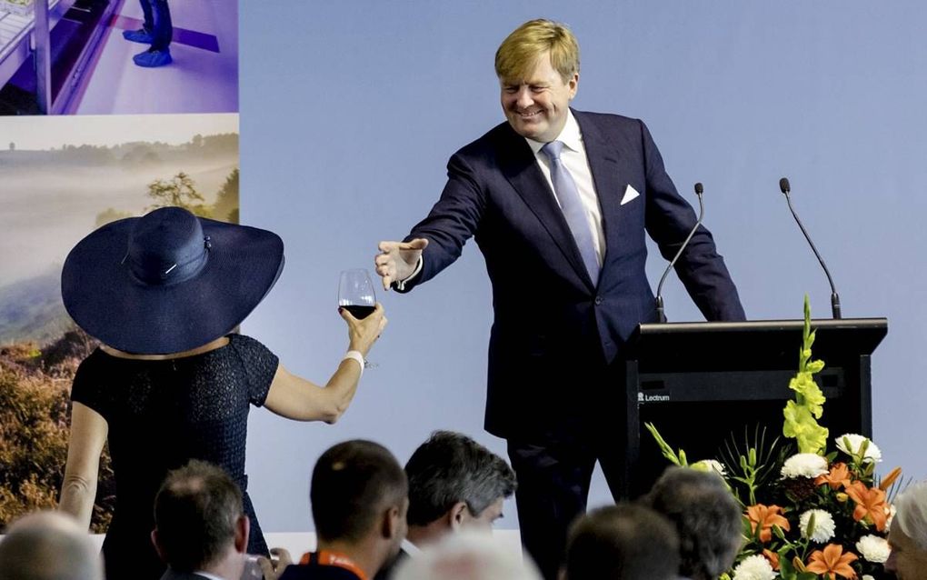 AUCKLAND. Koningin Máxima reikt koning Willem-Alexander een glas aan dat hij nodig heeft om te kunnen toosten. Het koningspaar rondde vandaag het staatsbezoek aan Nieuw-Zeeland af. beeld ANP, Robin van Lonkhuijsen