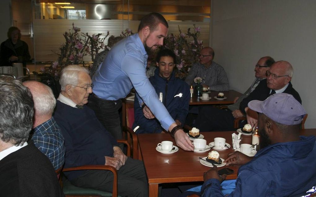 Glazenwassers van Fortron delen koffie en gebak uit aan bewoners van Nebo in Zwijndrecht.  beeld André Bijl