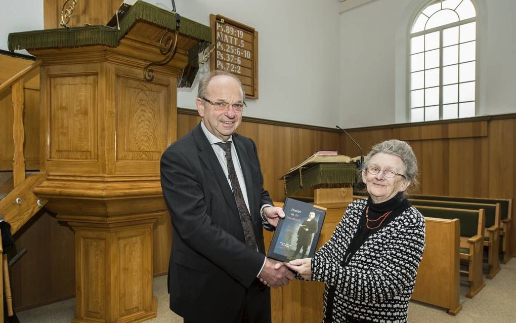 Auteur J. M. Vermeulen presenteert het eerste exemplaar van de biografie over ds. L. Boone. beeld Wim van Vossen