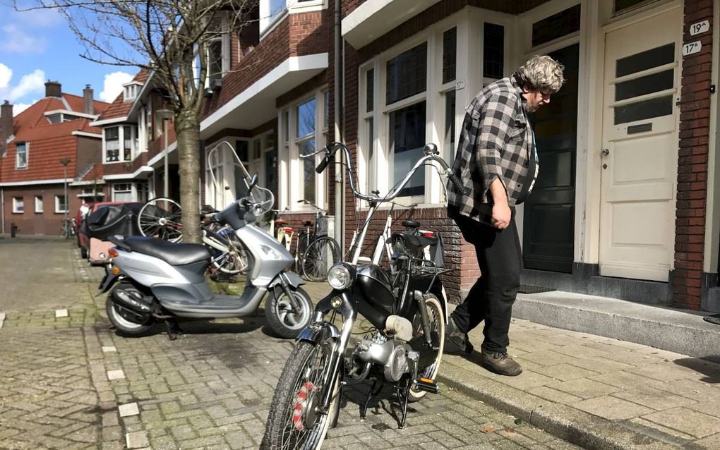 De wijk Schiedam-Oost kampt met grote problemen. Op straat sleutelt Peter Boon aan zijn Puch. Oldtimer met hippiestuur. beeld Gerard ten Voorde