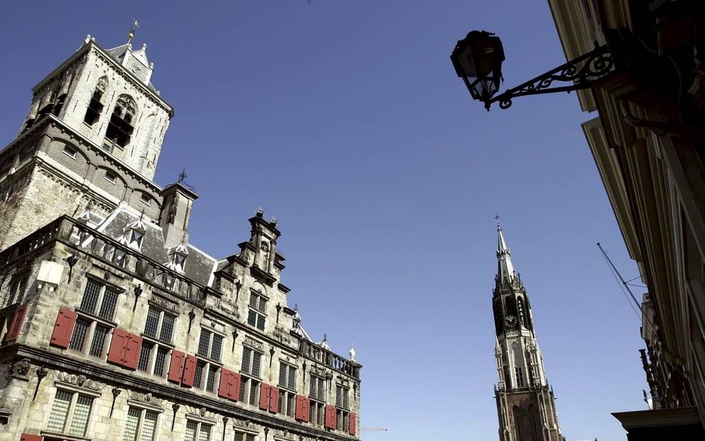 Dankzij VOC-geld kon Delft een mooi stadhuis bouwen. Rechts de Nieuwe Kerk waar veel Oranjes liggen begraven. beeld ANP, Lex van Lieshout