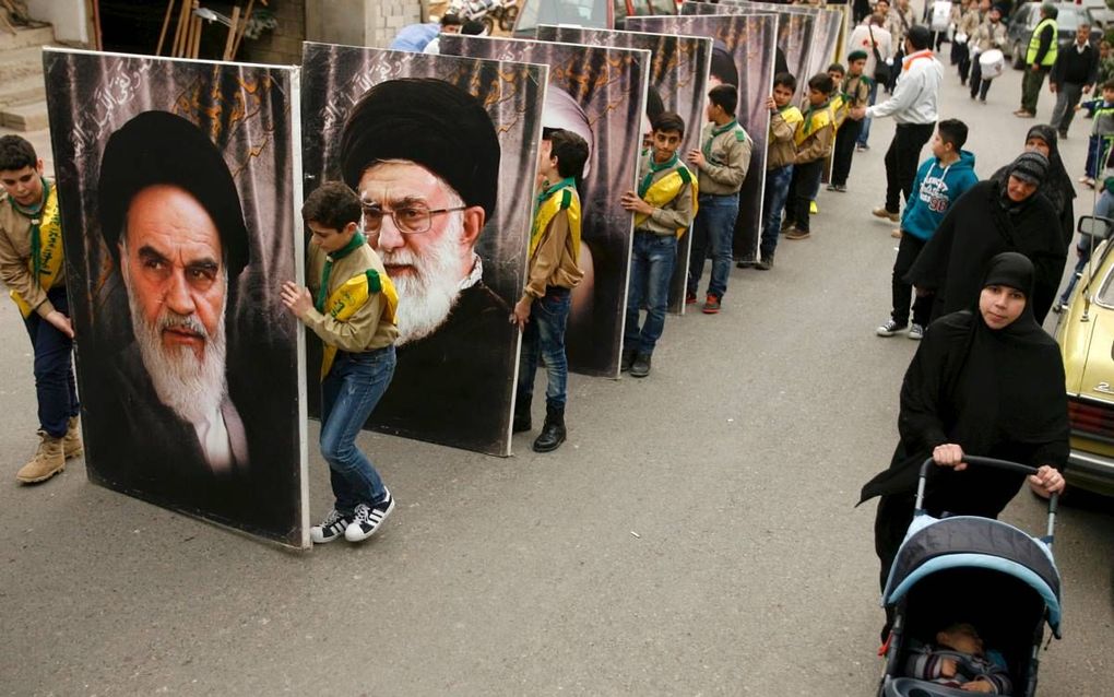 Aanhangers van de Hezbollah­beweging lopen met een portret van ayatollah Khomeini.  beeld AFP, Mahmoud Zayyat