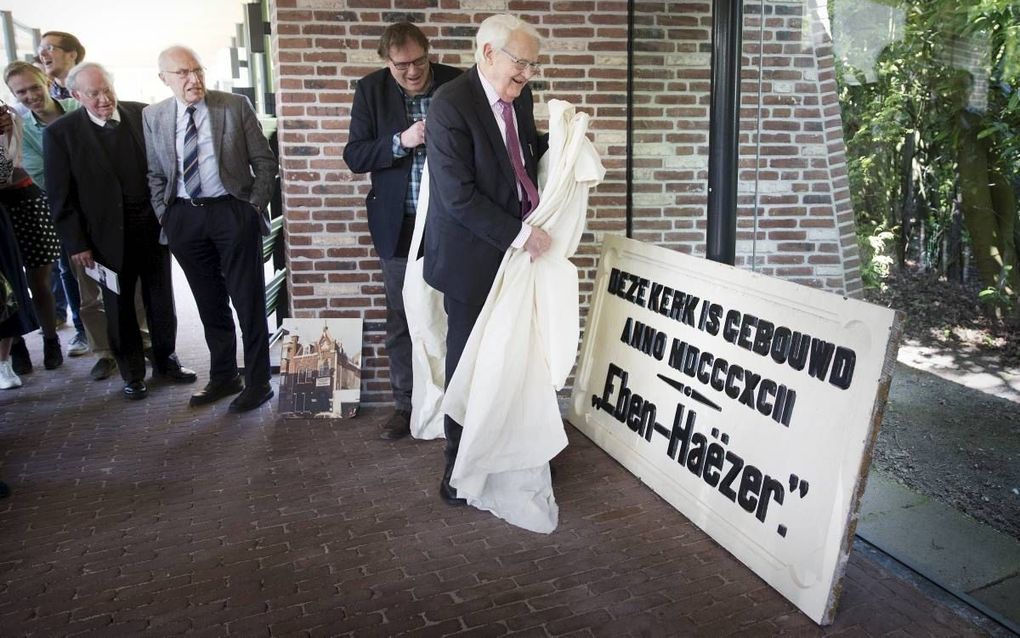 Prof. dr. W. van ’t Spijker opende donderdag in het gebouw van de Theologische Universiteit Apeldoorn een expositie over 125 jaar Christelijke Gereformeerde Kerken. Hij onthulde een gevelsteen uit 1892, van de voormalige Eben-Haëzerkerk in Den Haag. beeld