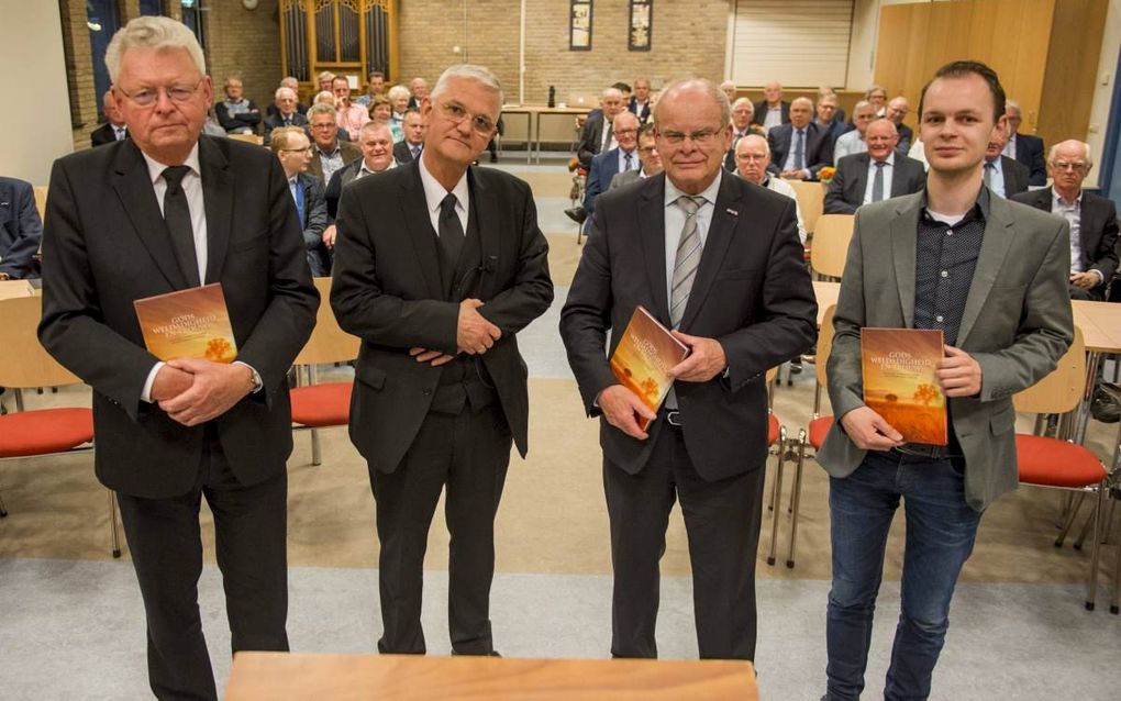 Het jubileumboek van de Mannenbond werd door voorzitter ds. E. Bakker (tweede van links) uitgereikt aan ds. J. J. van Eckeveld (l.), J. J. Rietveld en Hendrik Verhoef (r.). beeld Cees van der Wal