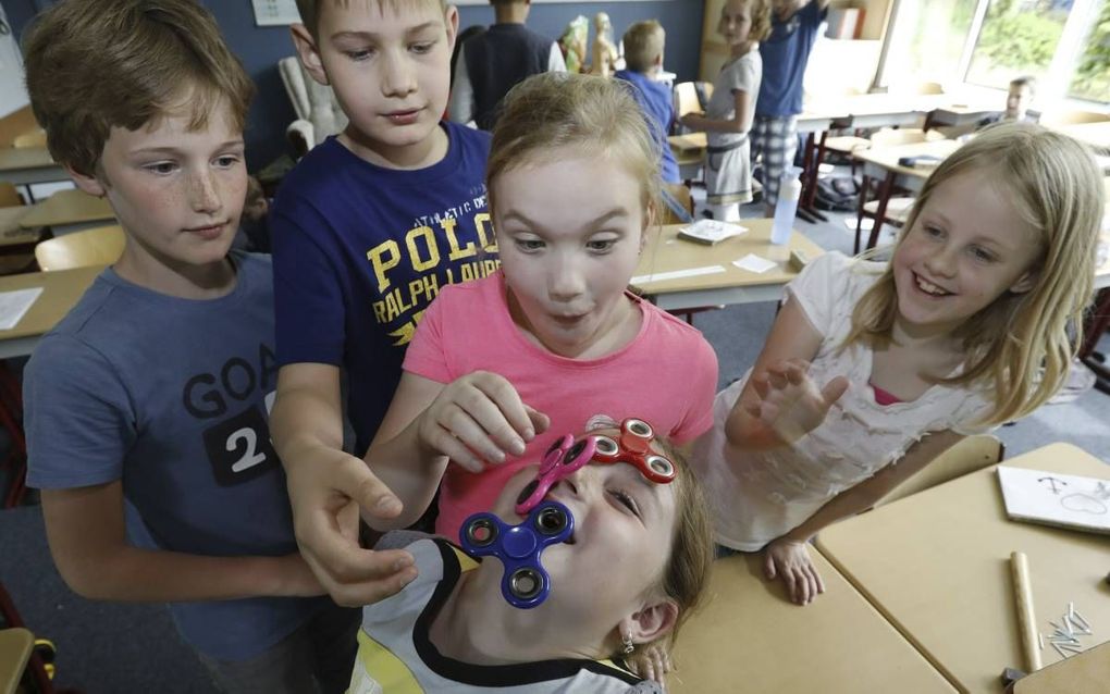 Kinderen uit groep 5/6 van de Johannes Calvijnschool in Veenendaal spelen met spinners. beeld VidiPhoto