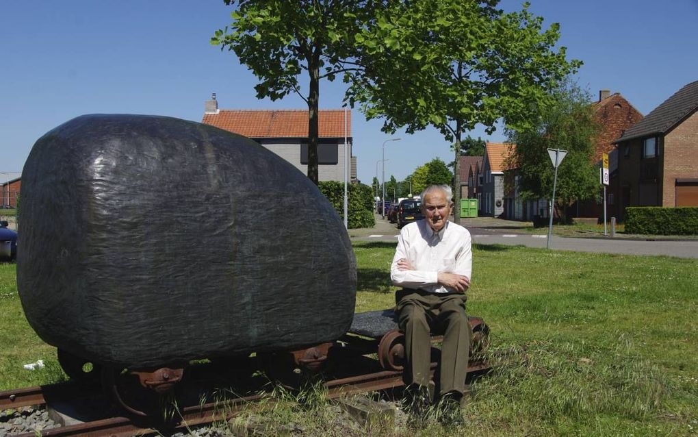 Johan den Brouwer bij een monument in Axel dat herinnert aan de lijn Mechelen-Terneuzen: een bronzen kever op treinwieltjes. beeld Van Scheyen Fotografie