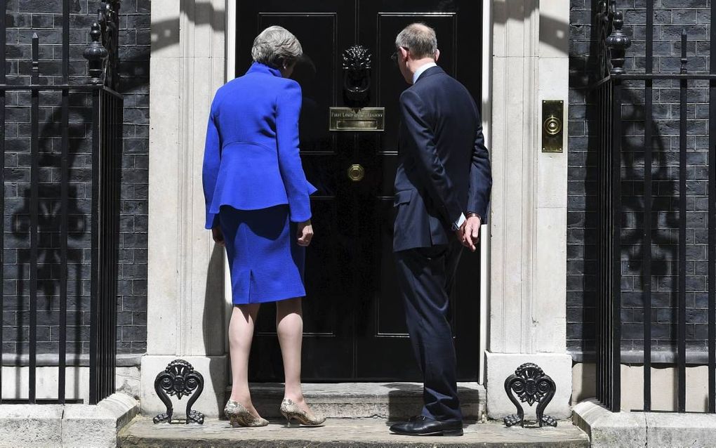 LONDEN. De Britse premier Theresa May mag haar ambtswoning Downing Street 10 weer in om verder te regeren. Dat ging wel met enigszins gebogen schouders gepaard, na de teleurstelling van de verkiezingsuitslag van donderdag. beeld EPA, Andy Rain