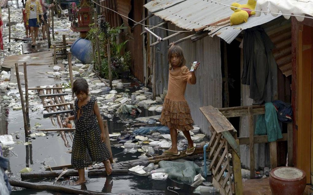 Het aantal kinderen dat werkzaam is in de seksindustrie in Cambodja daalt. Foto: kinderen in een sloppenwijk van Phnom Penh, de hoofdstad van Cambodja. beeld AFP, Tang Chhin Sothy