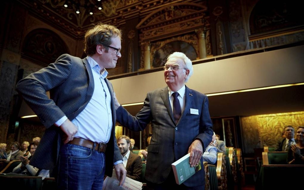 Dr. Remco van Mulligen (links) overhandigde gisteren de door hem geschreven biografie over prof. dr. Egbert Schuurman (r.) aan de hoofdpersoon zelf. De boekpresentatie had plaats is de zaal van de Eerste Kamer in Den Haag, waar Schuurman vele jaren als se