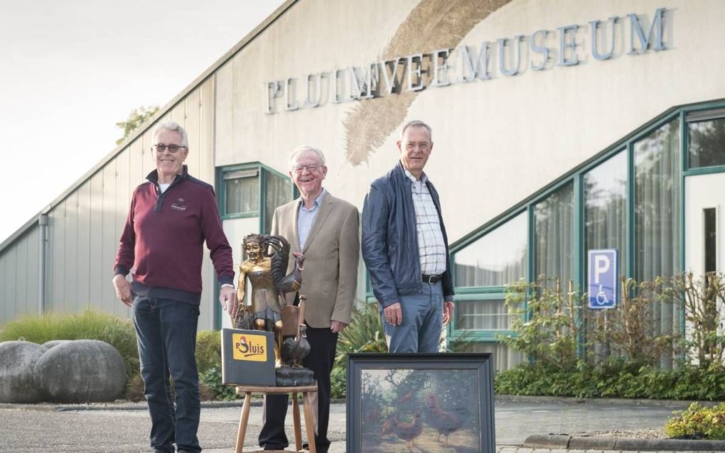 Bestuurslid R. van Broekhuizen, voorzitter C. Floorijp en vrijwilliger J. Jacobsen van het Pluimveemuseum in Barneveld met voorwerpen die tentoongesteld zullen worden in de geplande kunsthal. beeld Niek Stam