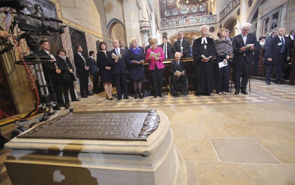 De Duitse bondskanselier Merkel (in het roze) en andere hoogwaardigheidsbekleders waren gisteren in de Slotkerk in Wittenberg om 500 jaar Reformatie te herdenken.   beeld EPA