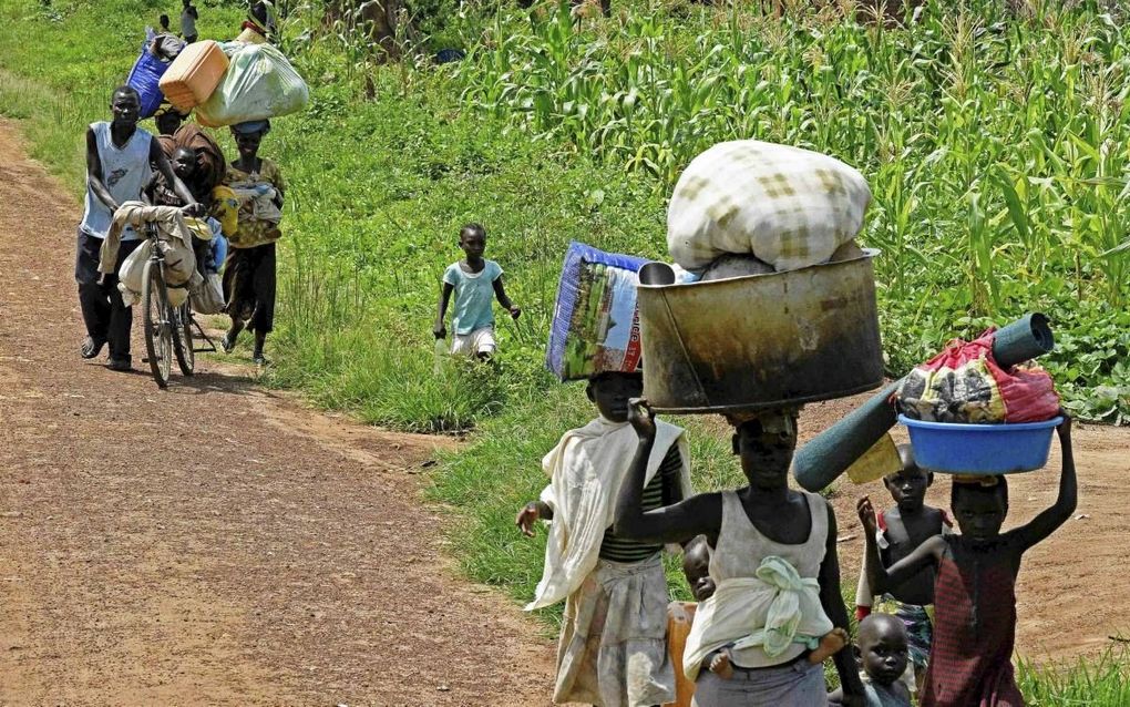 Zuid-Sudanese vluchtelingen passeren de grens in Kijaria, in het noorden van Uganda, juli 2017. Een derde van de bevolking van Zuid-Sudan is op de vlucht geslagen voor geweld. beeld AFP, Isaac Kasamani